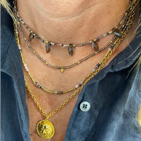 Woman wearing four Sabelline necklaces. The necklaces are in natural stones, mounted on wire or chain.